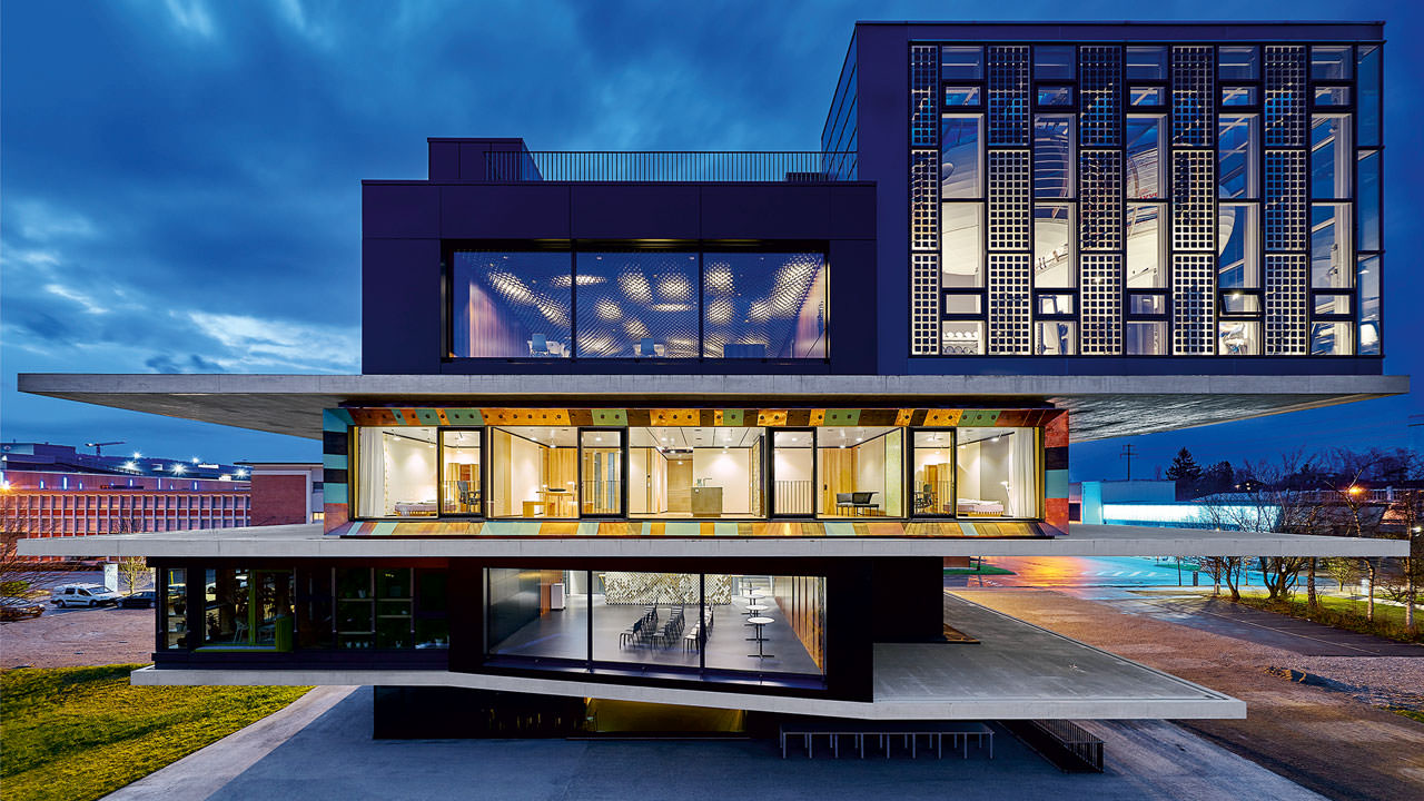 East view of NEST with the Urban Mining & Recycling unit illuminated in the center and the striking Solar Fitness & Wellness unit at top right.